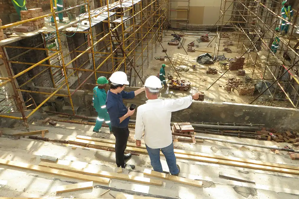 Construction workers discussing sustainable waste management solutions on a construction site.